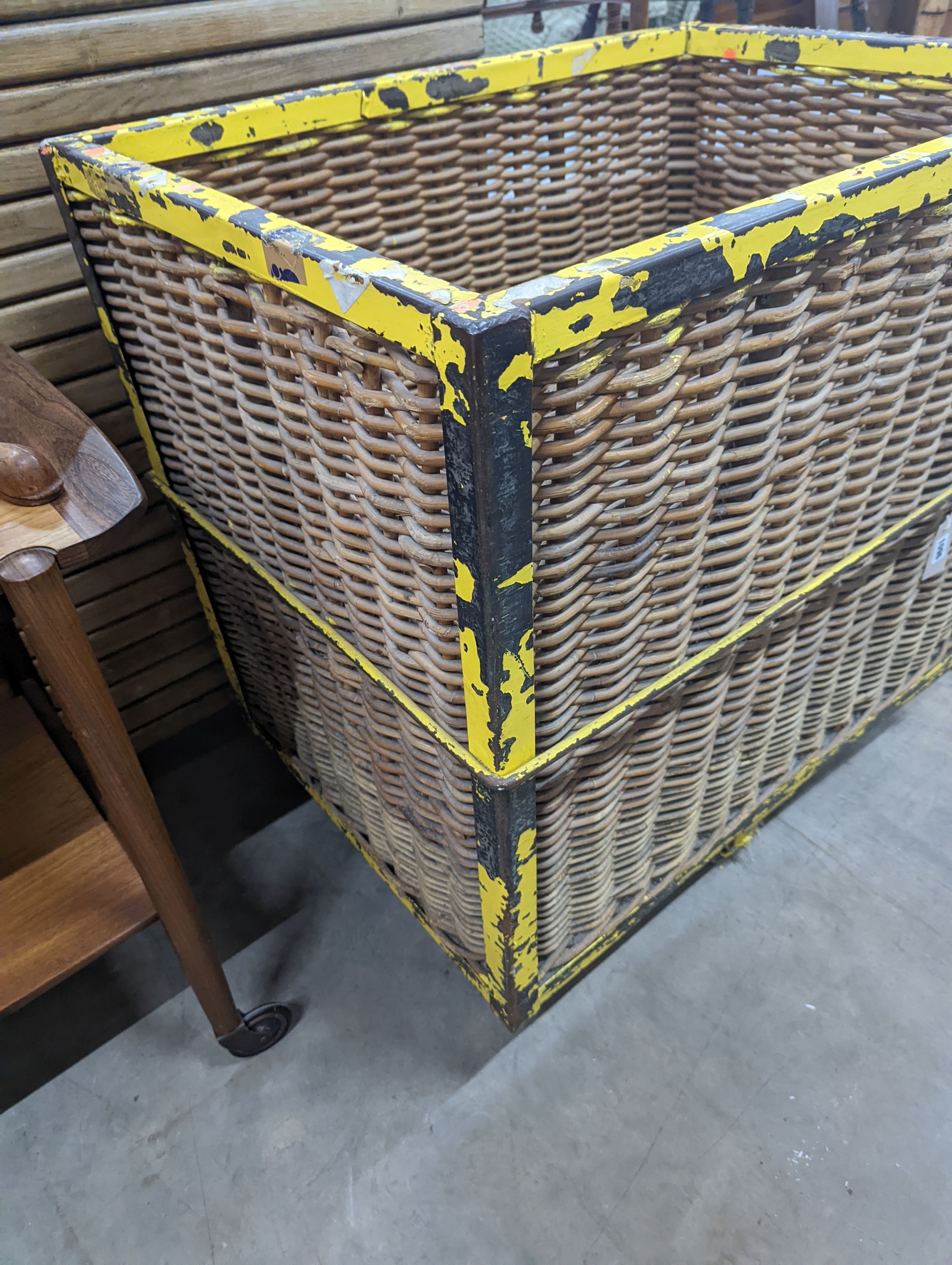 A vintage wicker and iron laundry basket on wheels, width 85cm, depth 61cm, height 87cm